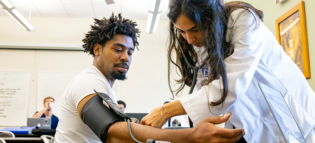 Doctor taking the blood pressure of a patient.